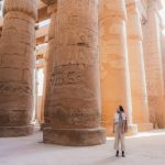Young Caucasian woman walking in the ancient Egyptian temple in Luxor
