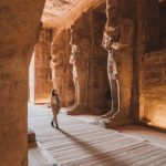 Young Caucasian woman walking inside Abu Simbel temples