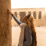 Female tourist touching columns of the temple of Horus in Edfu, Egypt. Esna and Aswan in Egypt.