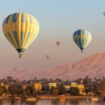 Hot air balloons over Nile river and Valley of Kings in Luxor at sunrise in Egypt
