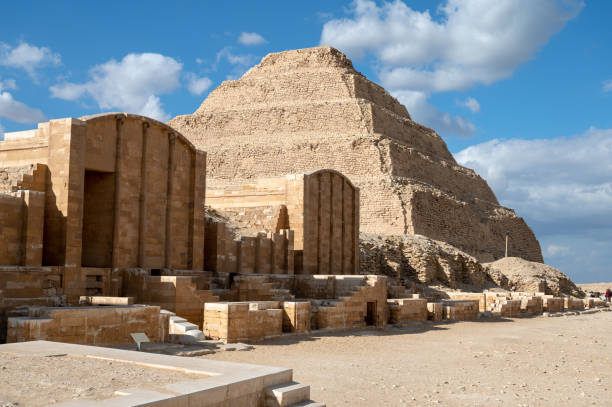 Djoser (or Djeser and Zoser) Step Pyramid, is an archaeological site in the Saqqara necropolis, Egypt, northwest of the ruins of Memphis. Built by Imhotep in the 27th century BC during the Third Dynasty for the burial of Pharaoh Djoser, the 6-tier, 4-sided structure is the earliest colossal stone building in Egypt. It is the central feature of a vast mortuary complex in an enormous courtyard surrounded by ceremonial structures and decoration.